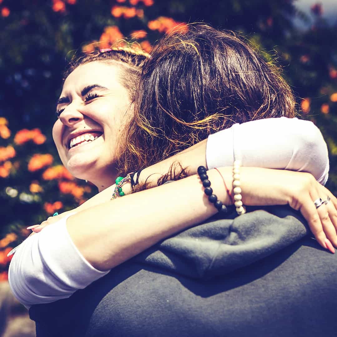 Two friends sharing a heartfelt embrace outdoors